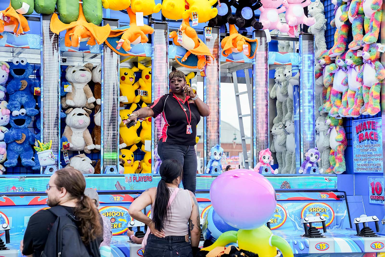 Guests aiming water guns at targets in carnival game